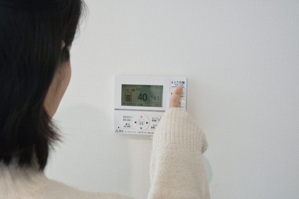 給湯器のパネルを操作する女性
